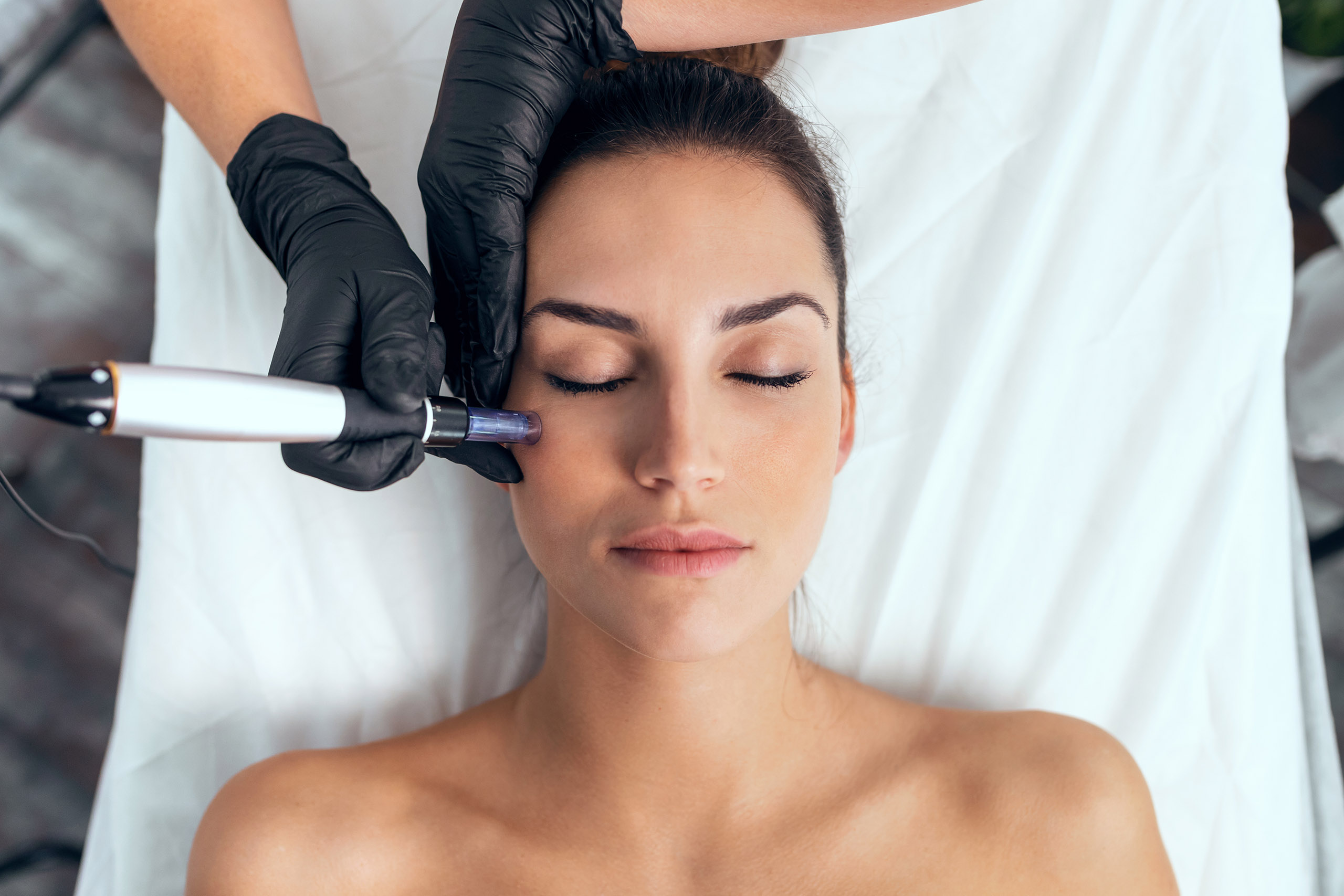 Shot of cosmetologist making mesotherapy injection with dermapen on face for rejuvenation on the spa center.