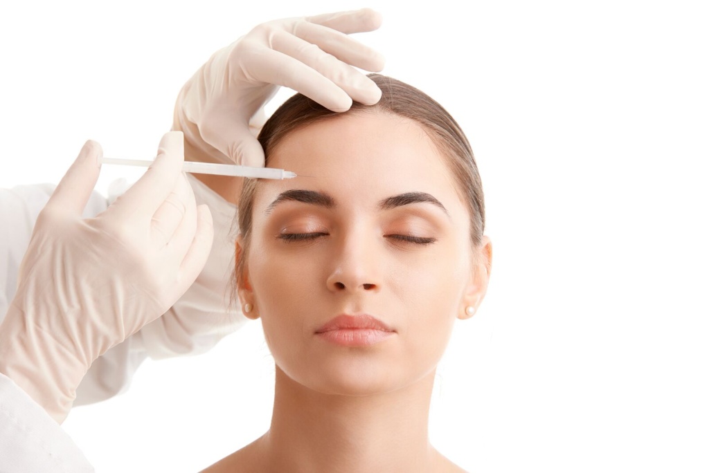 Woman with eyes closed receiving Botox in her forehead